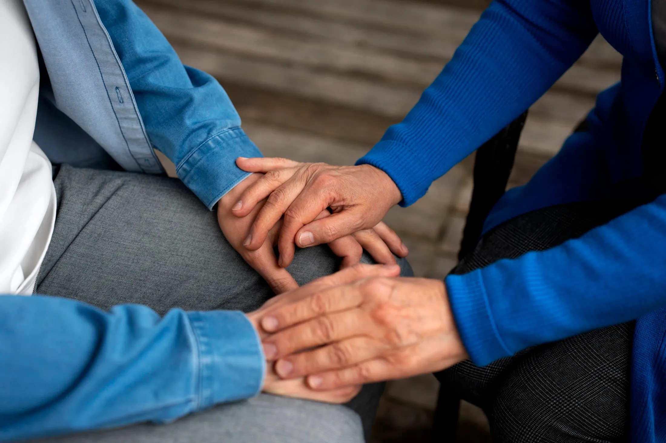 One person’s hands resting reassuringly on another’s